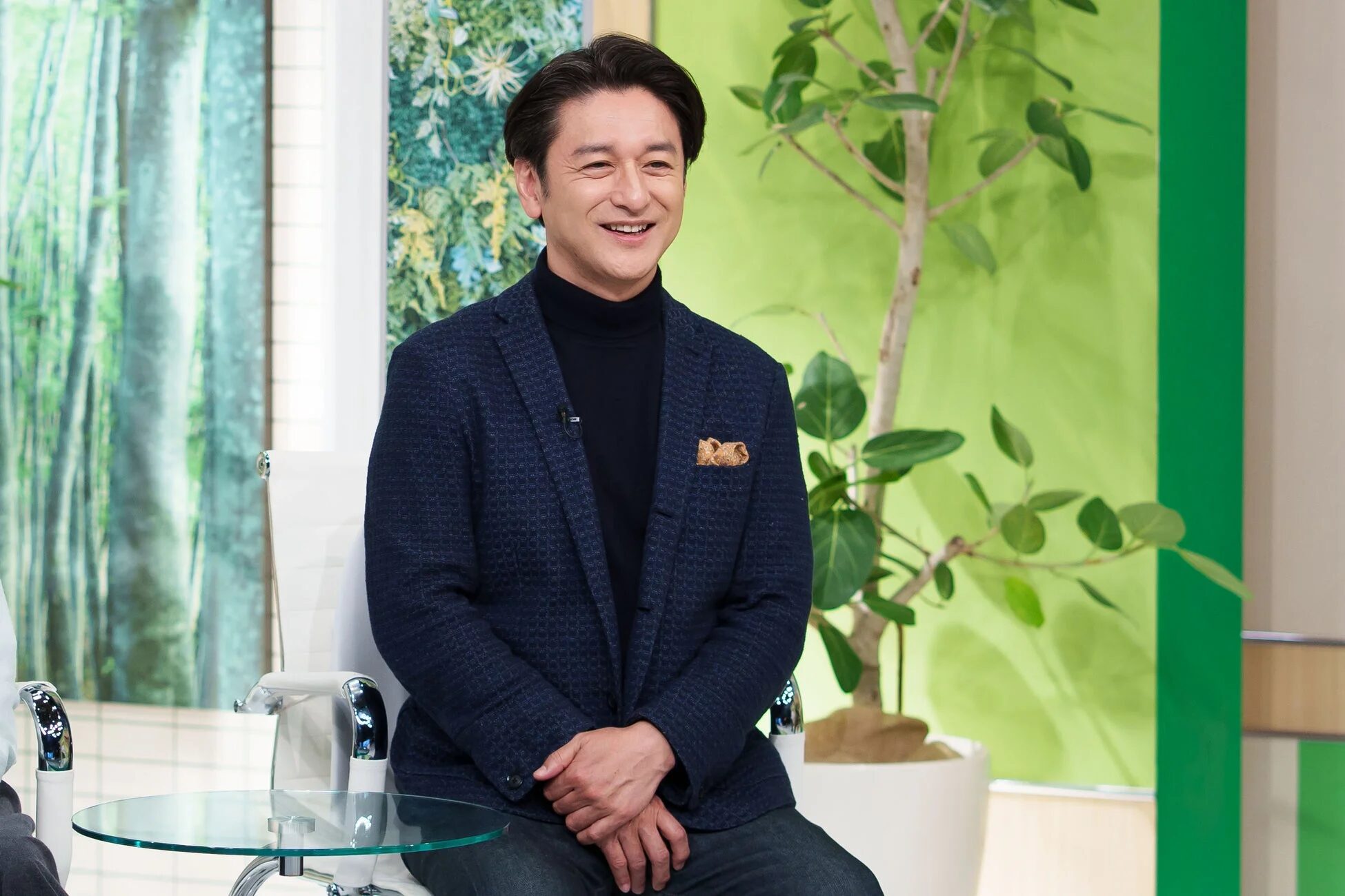 紺色のジャケットを着て笑顔の男性