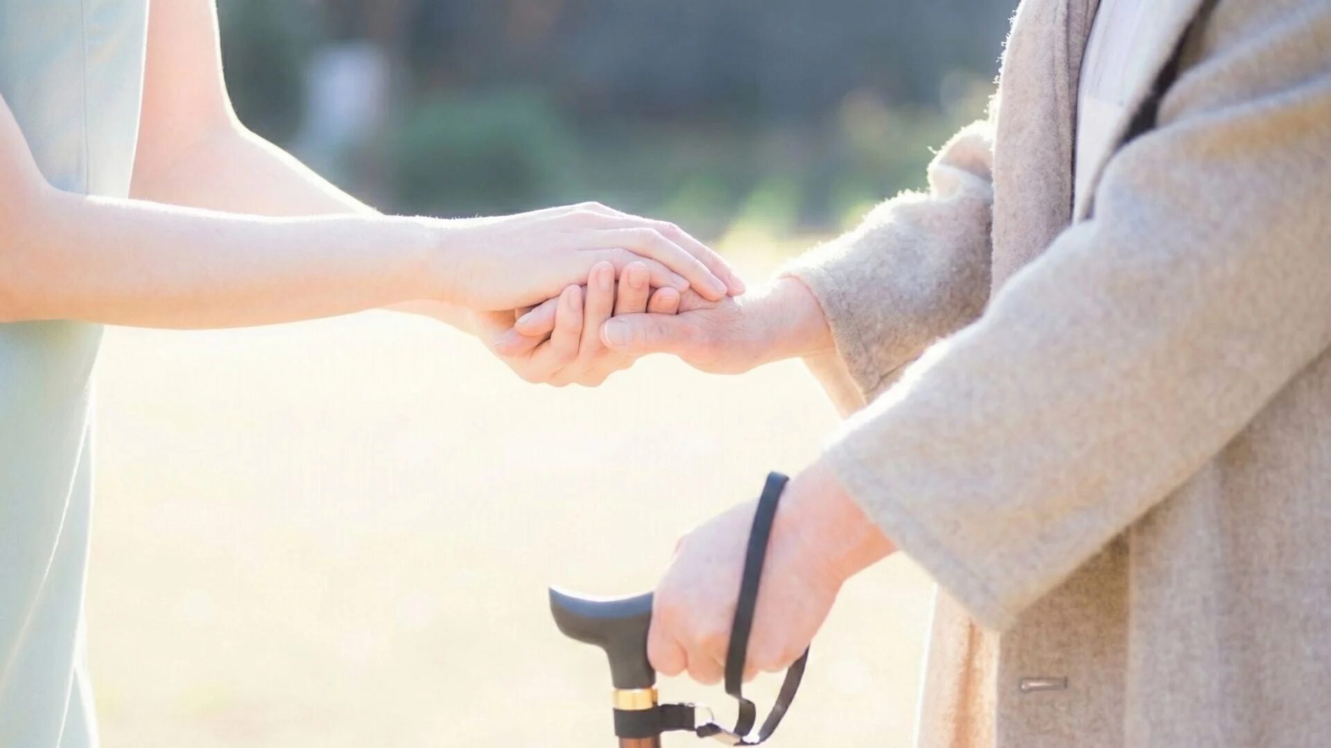 若い手が高齢者の手を優しく握り、支えている様子