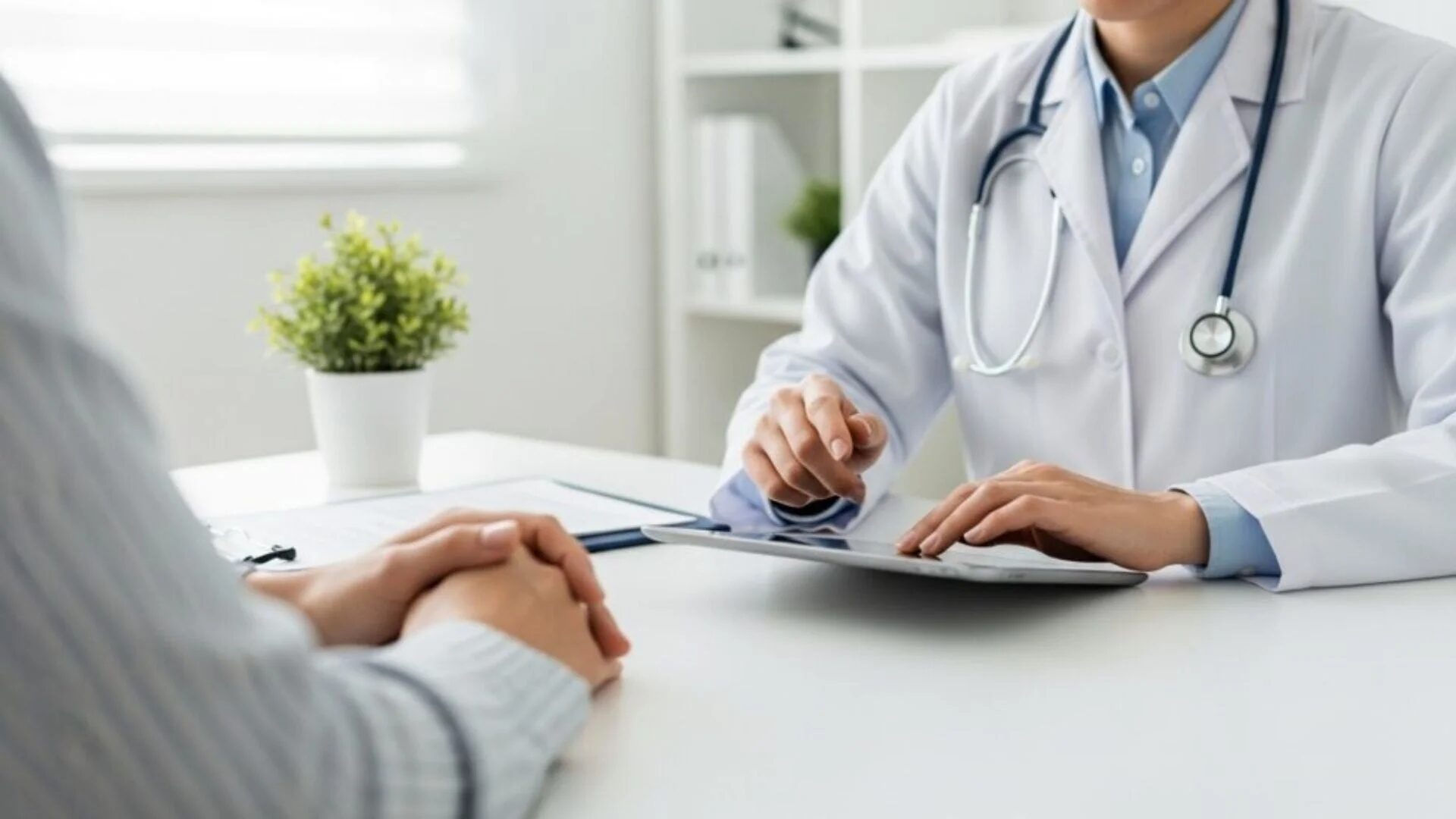 医師が患者と向かい合ってタブレットで説明している様子