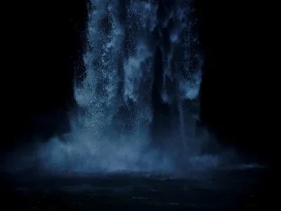 暗闇の中で大量の水が勢いよく流れ落ち、水しぶきと霧が立ち込めている様子を捉えた画像です。水の力強さと神秘的な雰囲気が感じられます。