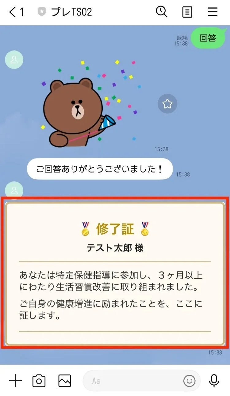 LINEのチャット画面で、特定保健指導に3ヶ月以上参加し、生活習慣改善と健康増進に励んだことに対する修了証が送られている様子が映されています。ブラウンのキャラクターがお祝いしています。