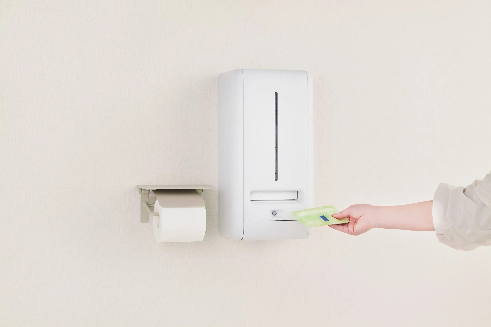 ナプキンをディスペンサーに挿入している様子