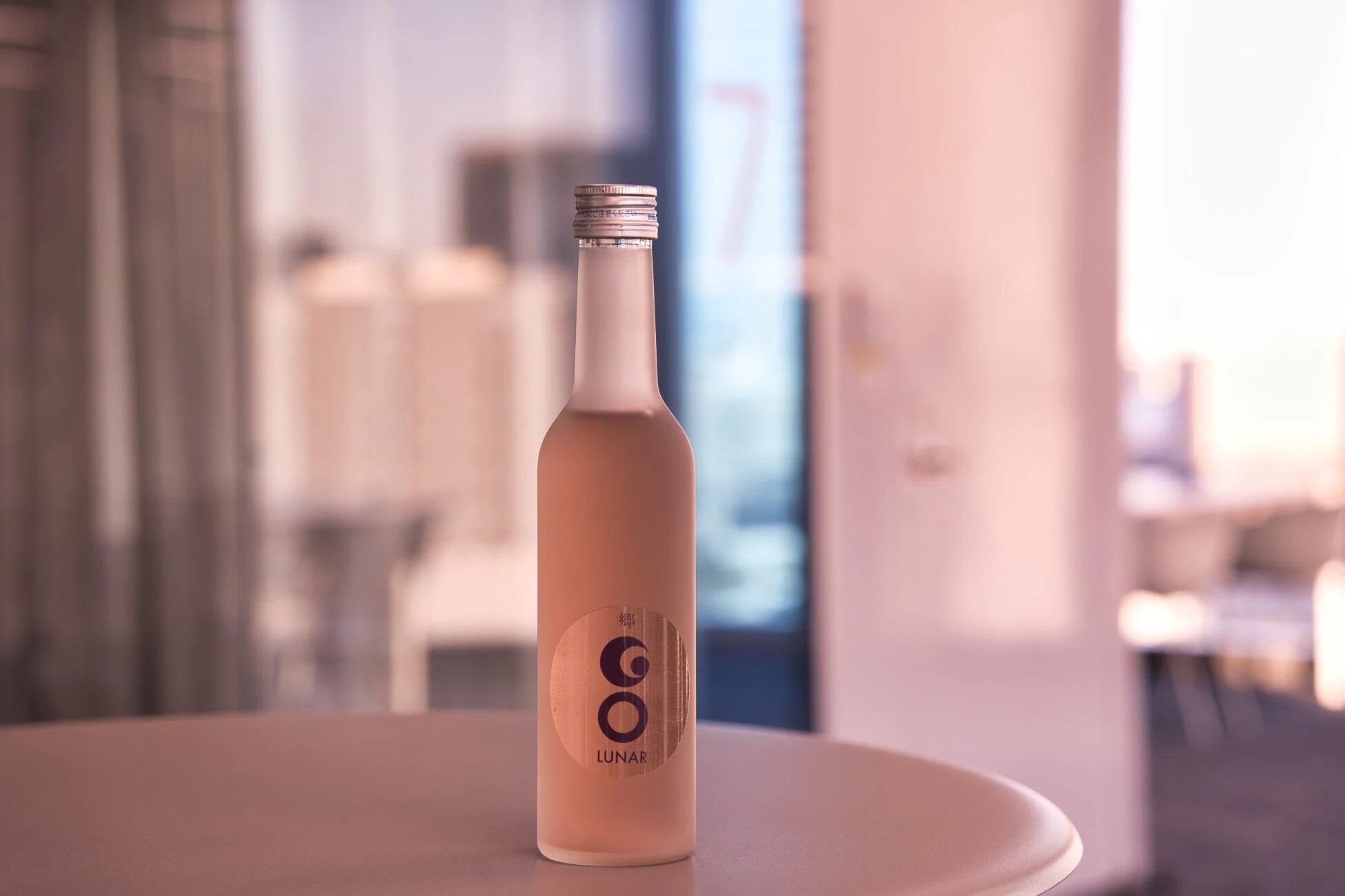 ピンク色の液体が入ったすりガラスのボトルがテーブルに置かれています。