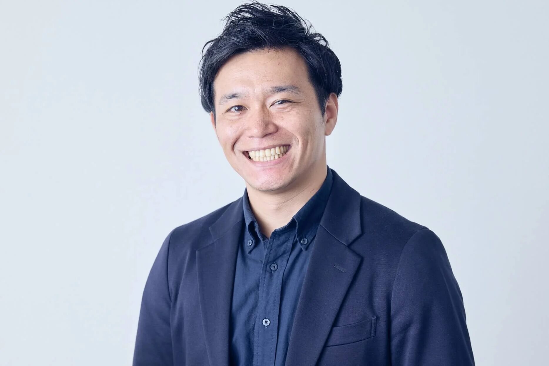 スーツ姿で笑顔の石井岳氏