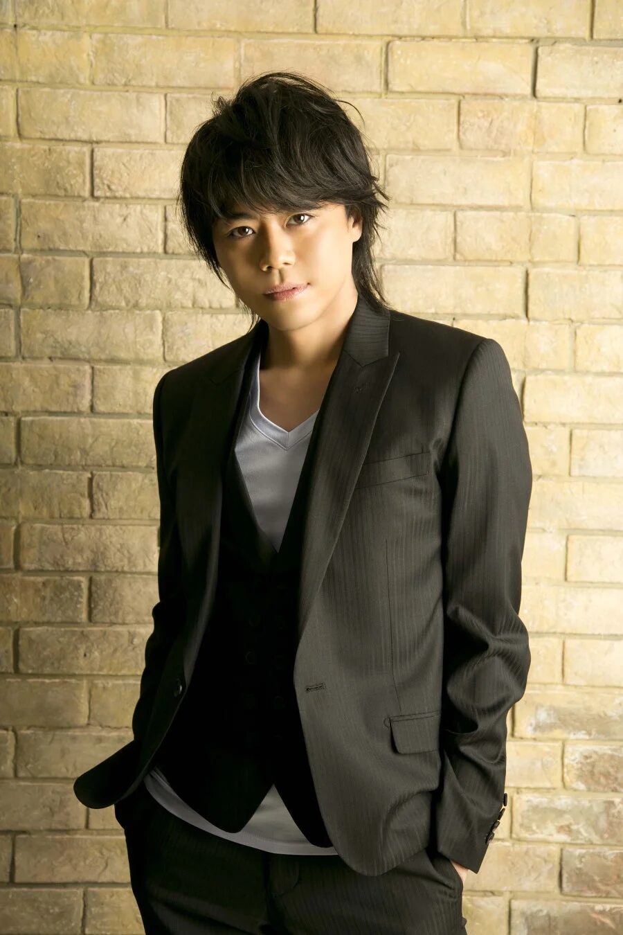 黒いスーツとベストを着用した若いアジア人男性