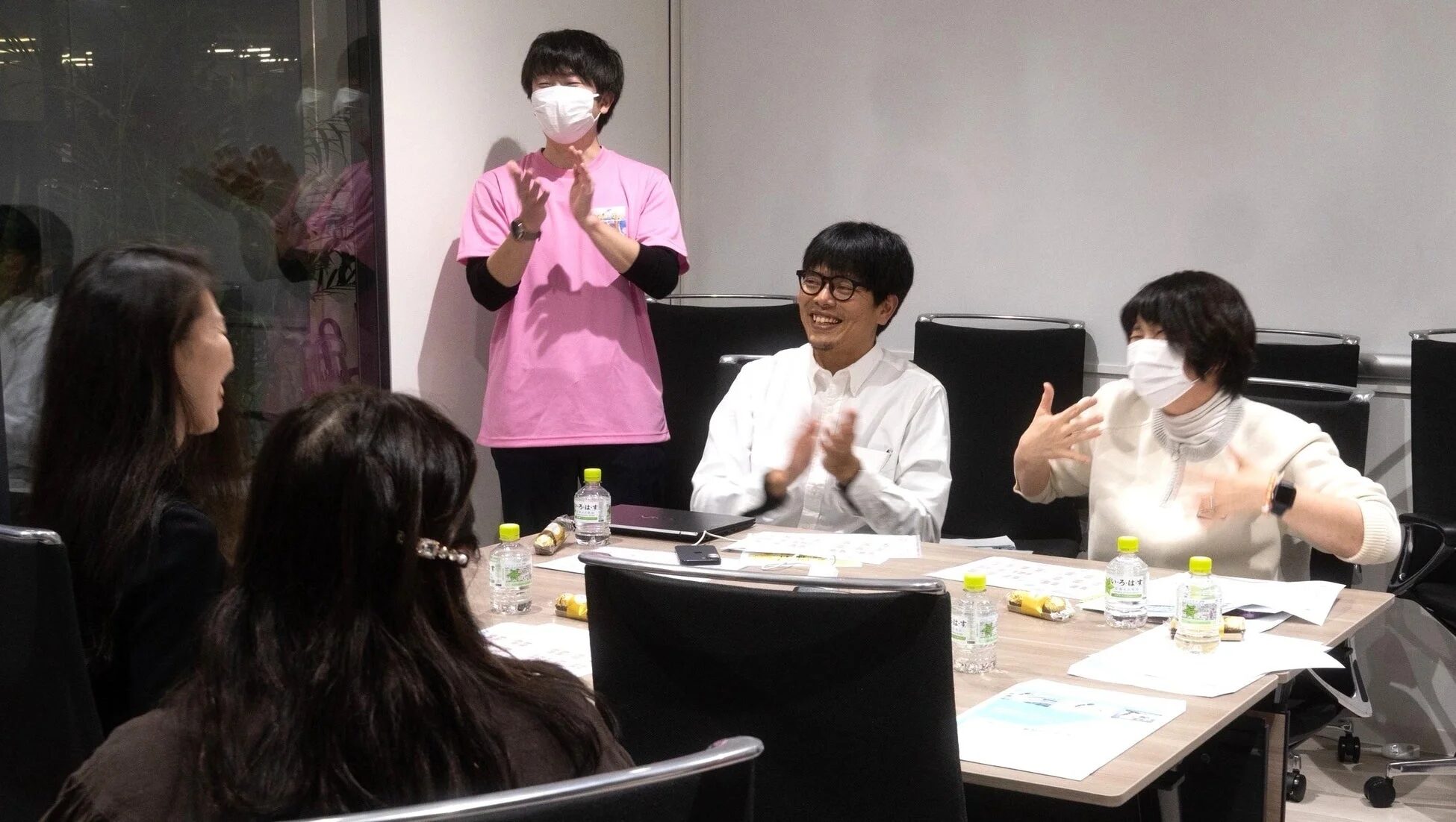 会議室で和やかに議論する参加者たち