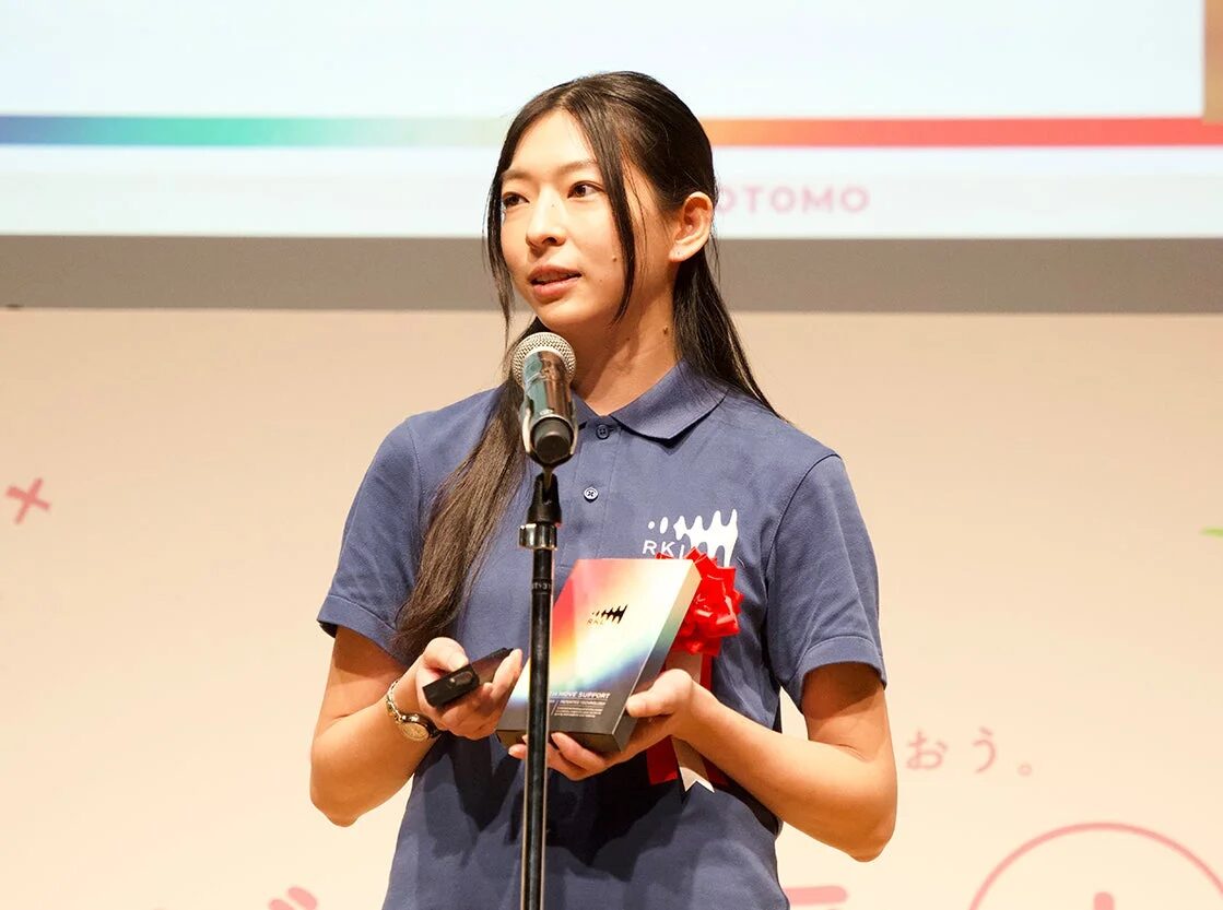 マイクの前でスピーチをする株式会社ヨミテ RKL担当 宮崎杏樹氏