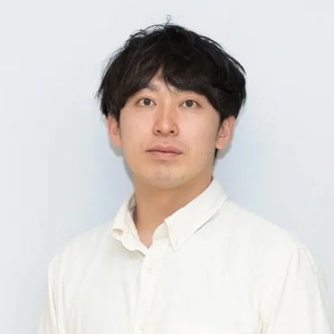 白い背景の前でカメラを見つめる男性のポートレート写真