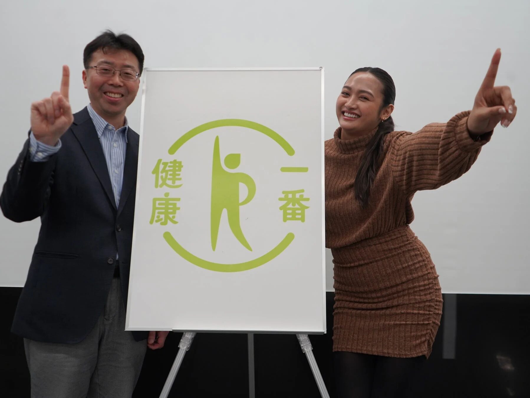 「健康一番」ボードと笑顔の男女