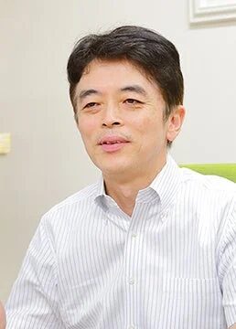 白いストライプのシャツを着た中高年の男性